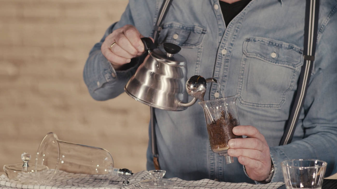 mann füllt kaffee in ein glas