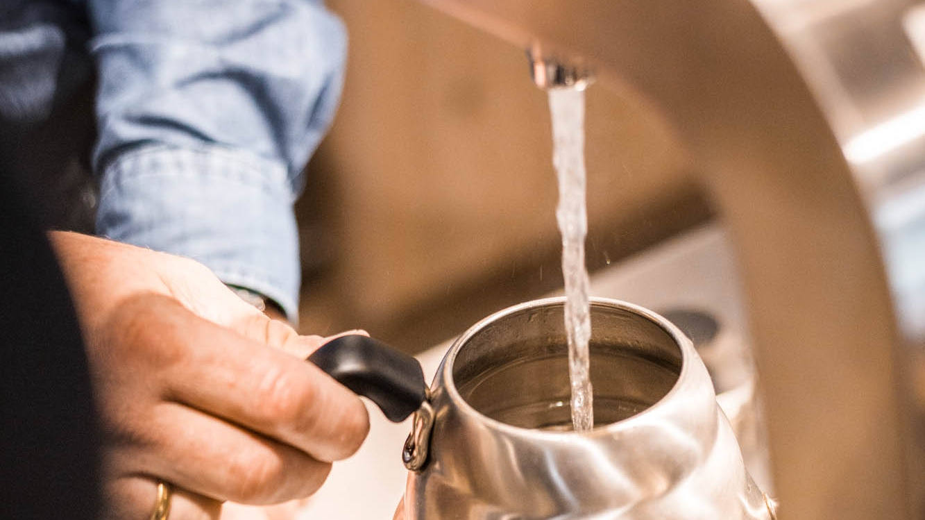 mann füllt wasser in kanne